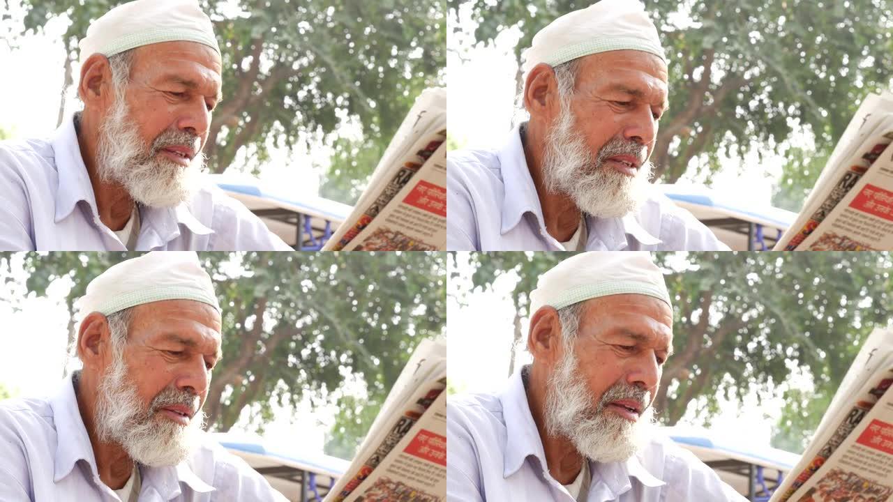 印度高级男子在户外阅读报纸