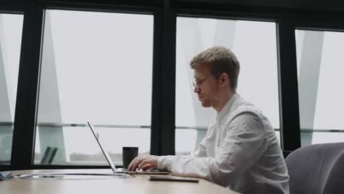 自由职业者程序员或翻译器正在咖啡馆或联合办公空间使用笔记本电脑，在键盘上键入文本