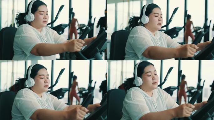 大型女性在健身车上锻炼时听音乐