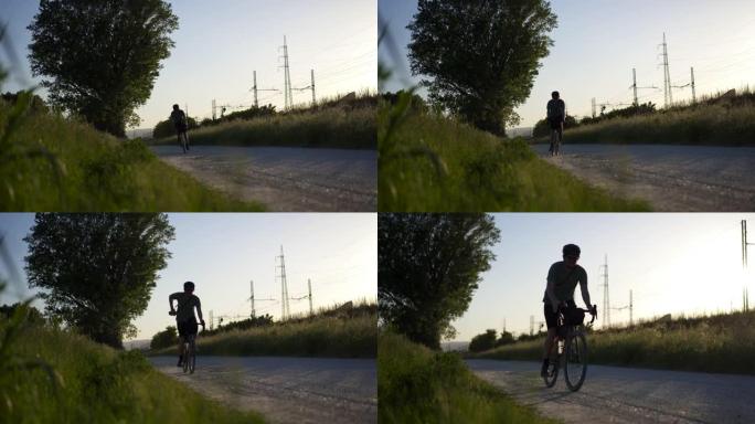 男子在日落时沿着砾石小径骑自行车