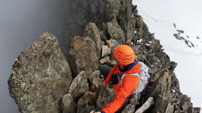 一队登山者沿着陡峭的山峰移动。对着镜头微笑。欧洲阿尔卑斯山