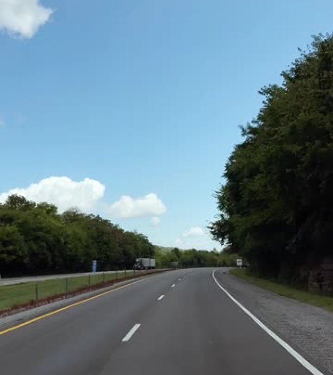 在一个阳光明媚的下午，田纳西州沿着树木状的州际I-40行驶的垂直视频汽车视点镜头