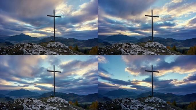 日落时岩石上的基督十字架，彩云。