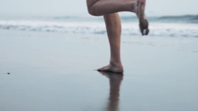 海滨慢跑训练。享受阳光和自由的女人。赤脚在湿沙上奔跑