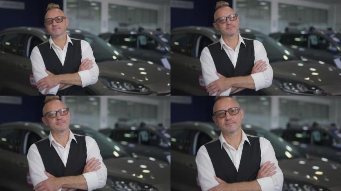 一名戴着眼镜的白人男子的肖像，他站在汽车经销店注视着照相机。自信英俊富有的买家在汽车展厅室内摆姿势。