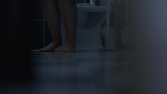 女性白人赤脚进入浴室坐在马桶上放下内裤。室内无法辨认的女人。卫生和个人卫生概念。