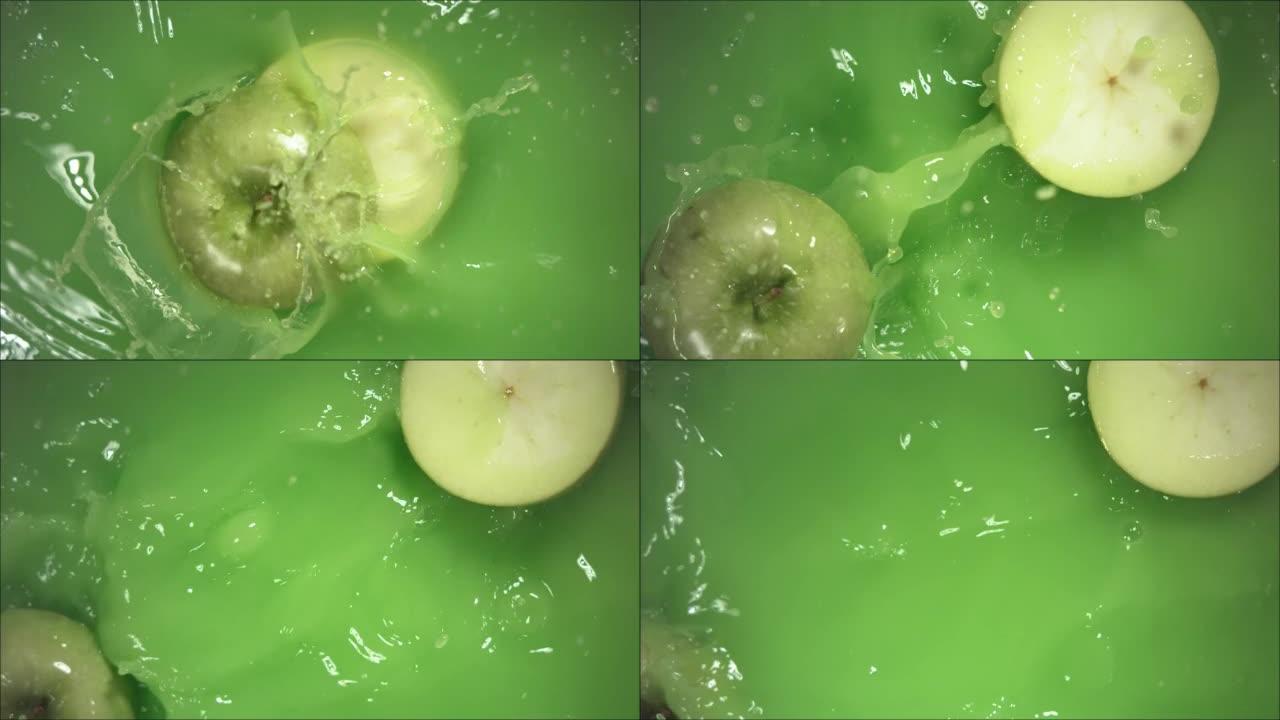 青苹果飞溅地落在果汁上，分成两半。