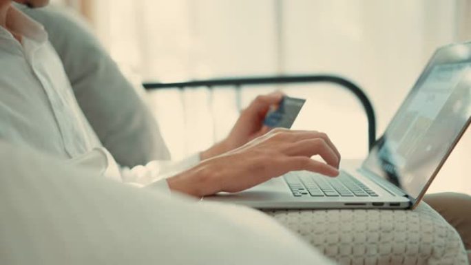 年轻夫妇在笔记本电脑上在线购物并使用信用卡付款