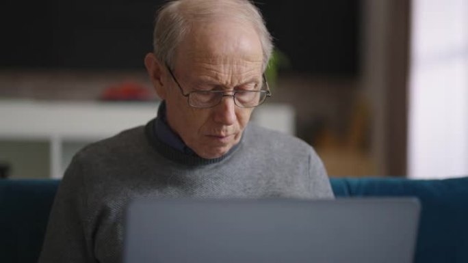 老皱纹秃顶的男人在他的家庭办公室工作，在公寓里的男性退休人员的肖像，使用笔记本电脑工作