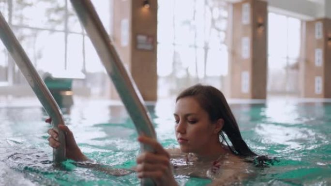 女人正在水疗中心度过周末，在游泳池游泳，放松身心，健身和健康中心