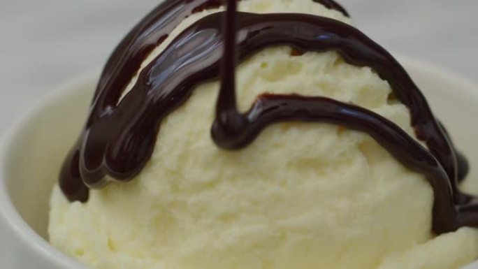巧克力酱倒在一勺香草冰淇淋上。用红色8k相机拍摄。