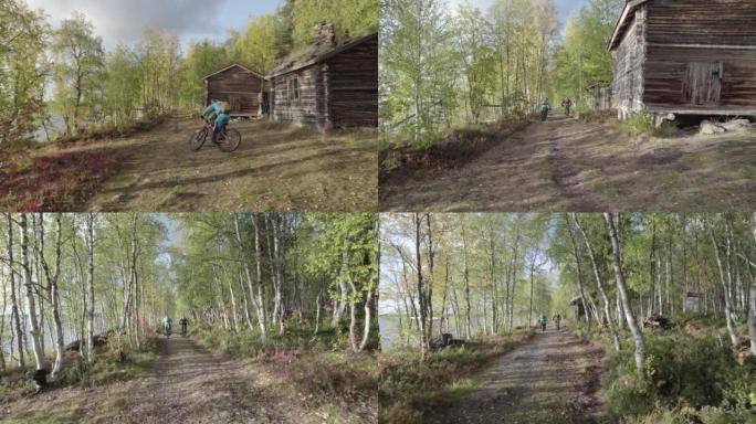 空中无人机拍摄了一对山地自行车夫妇在小屋附近的树林中行驶的路径