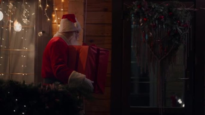 侧视图圣诞老人在冬天的街道上随身携带并交付礼物，来到门口，带着花环和圣诞节装饰品进入房屋。神奇的时刻