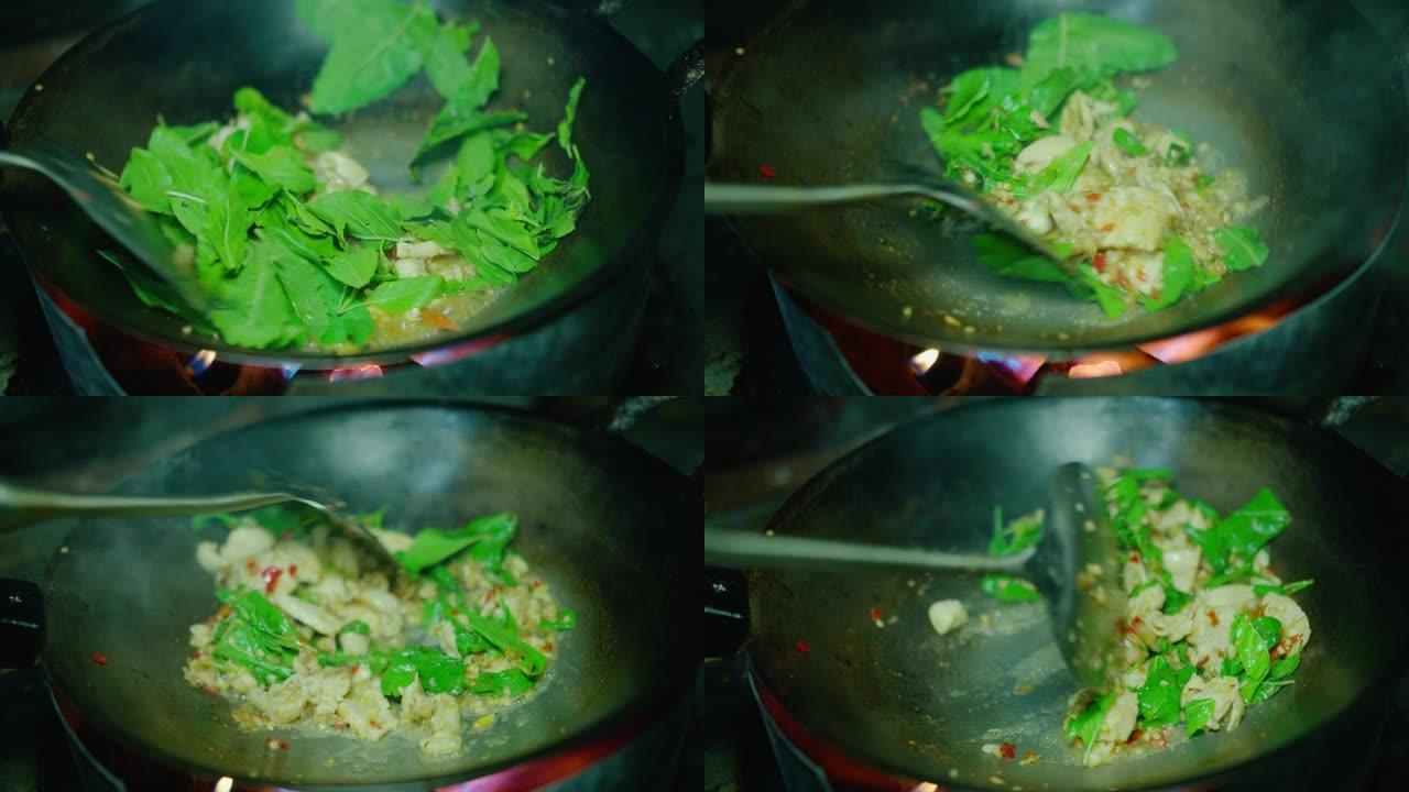 厨师在煎锅中用泰国圣罗勒烹调辛辣炒猪肉末的特写镜头，Pad Krapow是最受欢迎的泰国街头美食之一