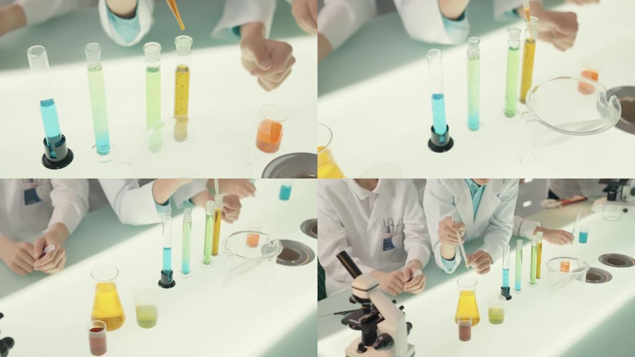 男孩在实验室进行科学实验。用移液器混合多色液体。特写