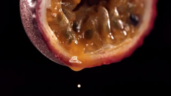 慢动作宏观拍摄来自减半的马拉库亚的流动百香果马拉库亚汁