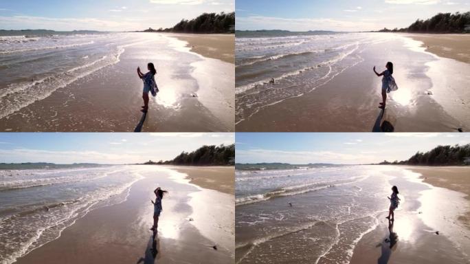空中拍摄，女人独自行走，晚上在海边用手机拍摄风景照片和自拍照。