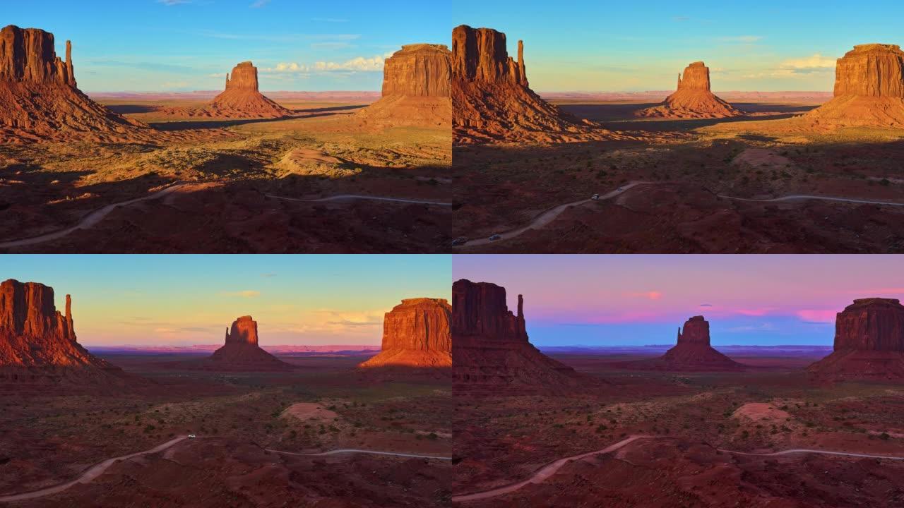 日落时的纪念碑谷。砂岩小山沙漠风光，雄伟的岩层和道路。时间流逝
