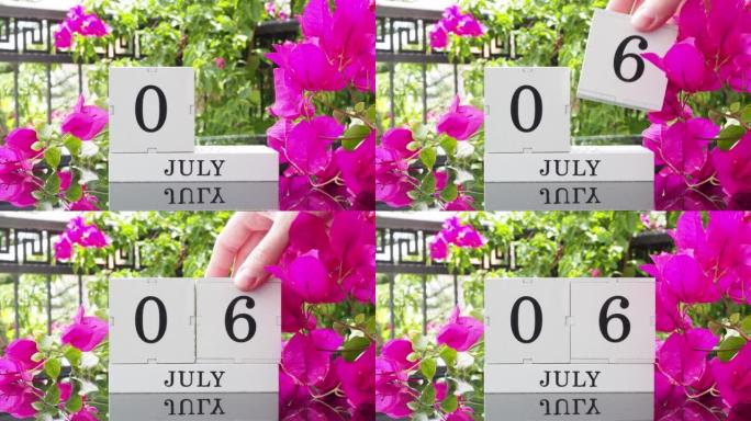 一个木制日历，有一个重要的活动，7月6日在一张有芙蓉花的桌子上，女人的手在日历上设定了日期。将日历翻