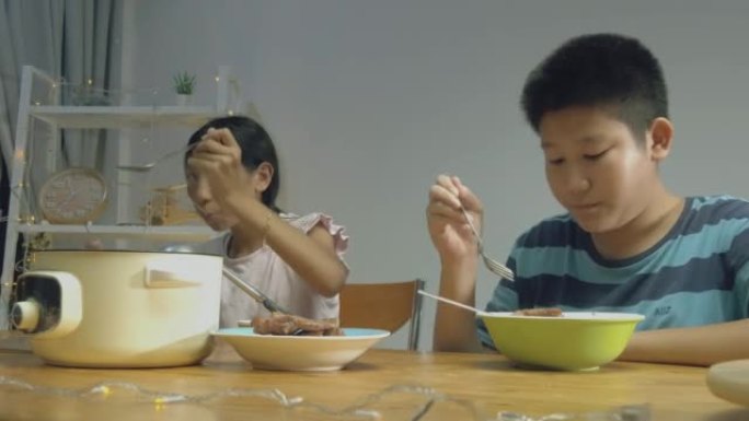 母亲提供食物，而孩子们则在晚上在家一起吃火锅sha锅，生活方式。