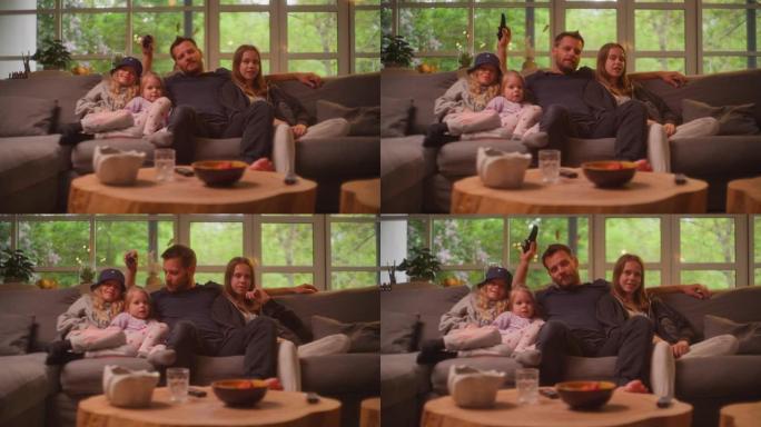 在家看电视。父亲和三个女儿一起度过时光