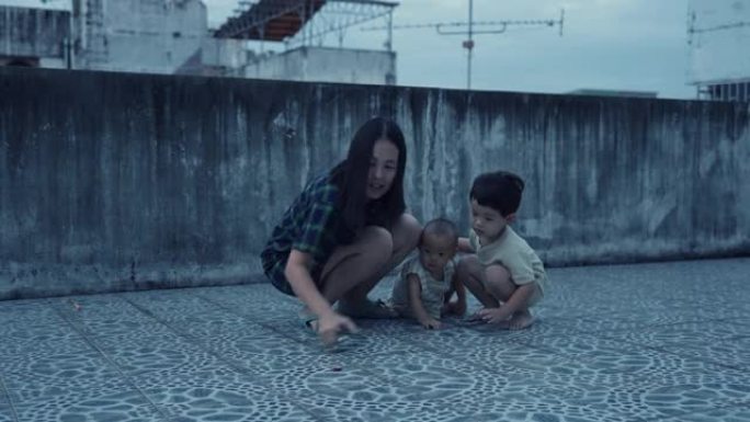 有母亲和两个儿子的亚洲家庭喜欢一起在屋顶上玩烟火和烟火