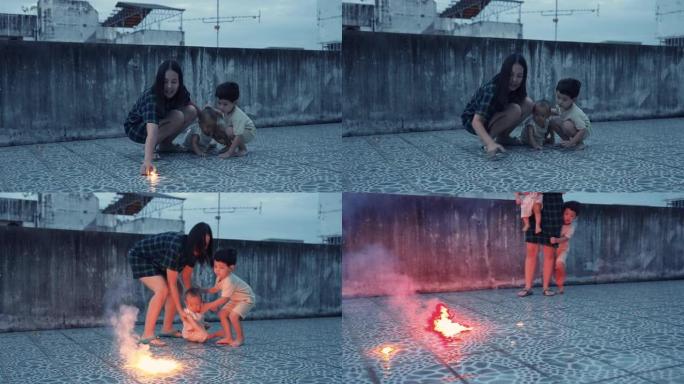 有母亲和两个儿子的亚洲家庭喜欢一起在屋顶上玩烟火和烟火