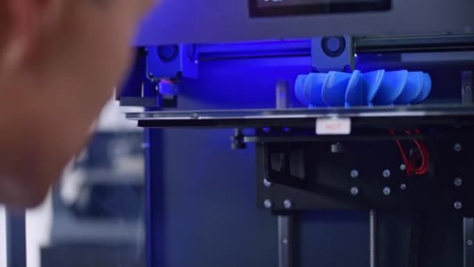 男性亚洲工程师俯瞰3D打印机内部模型的构建过程