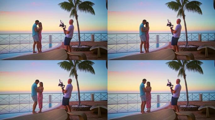 露台上浪漫的日落。美丽的夫妇摆姿势拍照。模特和摄影师的剪影