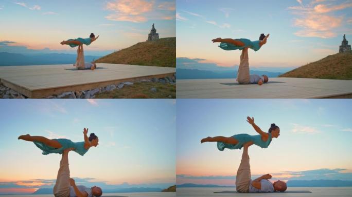 CS男女在日落时在山上摆瑜伽姿势