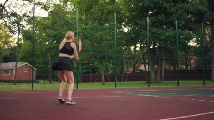 运动女子正在打网球场，用球拍击球，慢动作射击，网球课