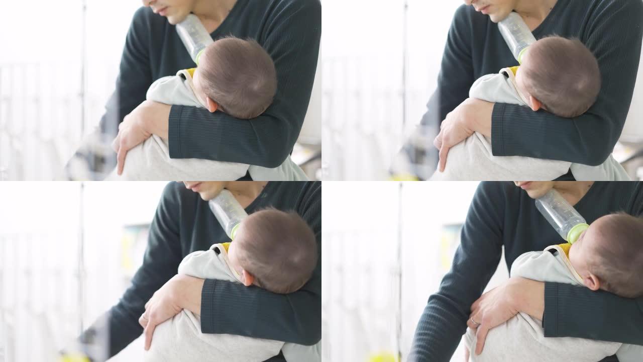 亚洲男子在照顾婴儿的同时做家务