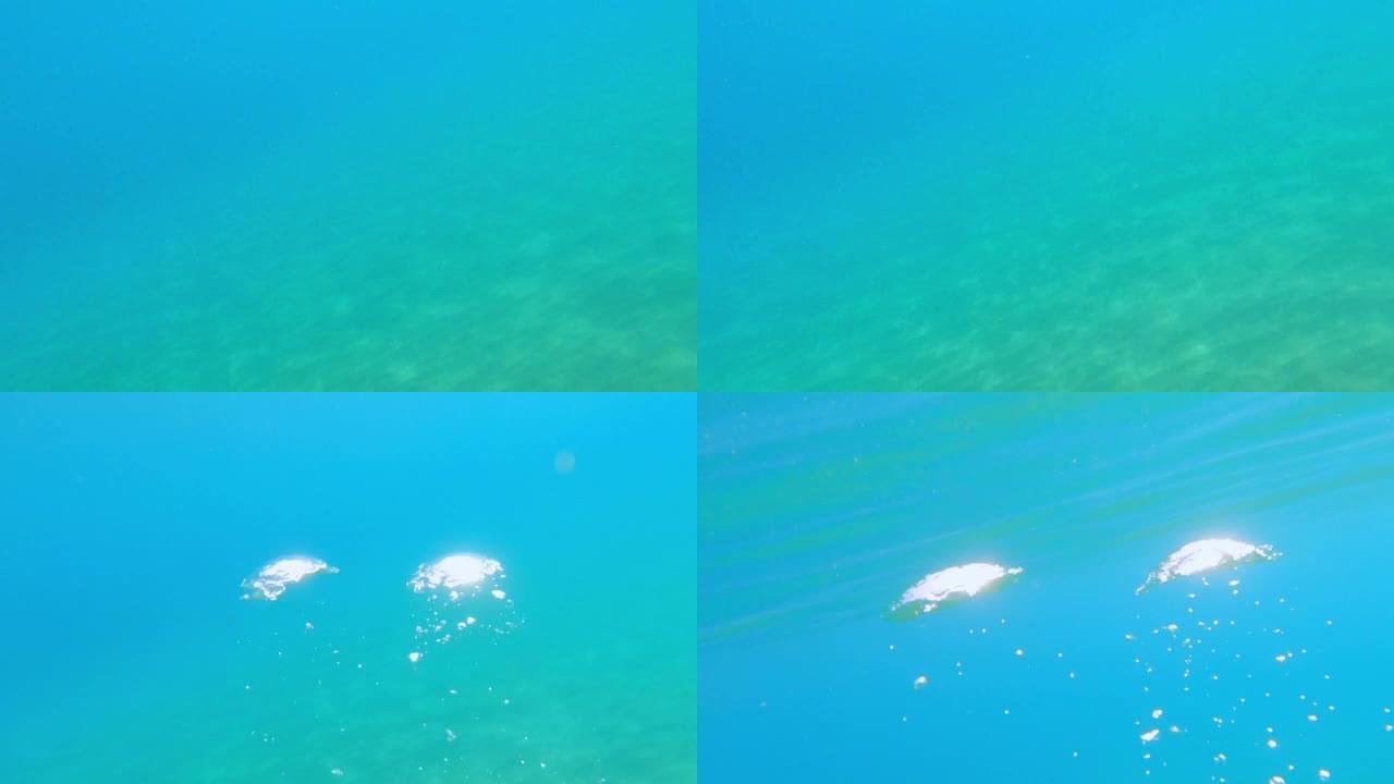 潜水员从底部游到海面拍摄气泡