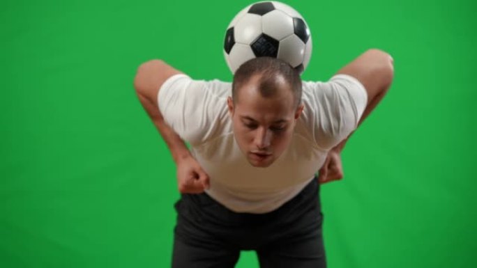 年轻的白人男子用手慢动作捕捉背部的足球。专业年轻运动员在chromakey绿屏背景模型训练。