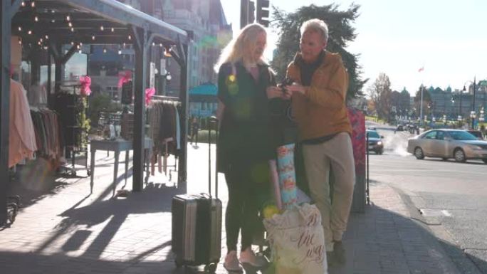 成熟的夫妇带着旅行行李探索维多利亚海滨街
