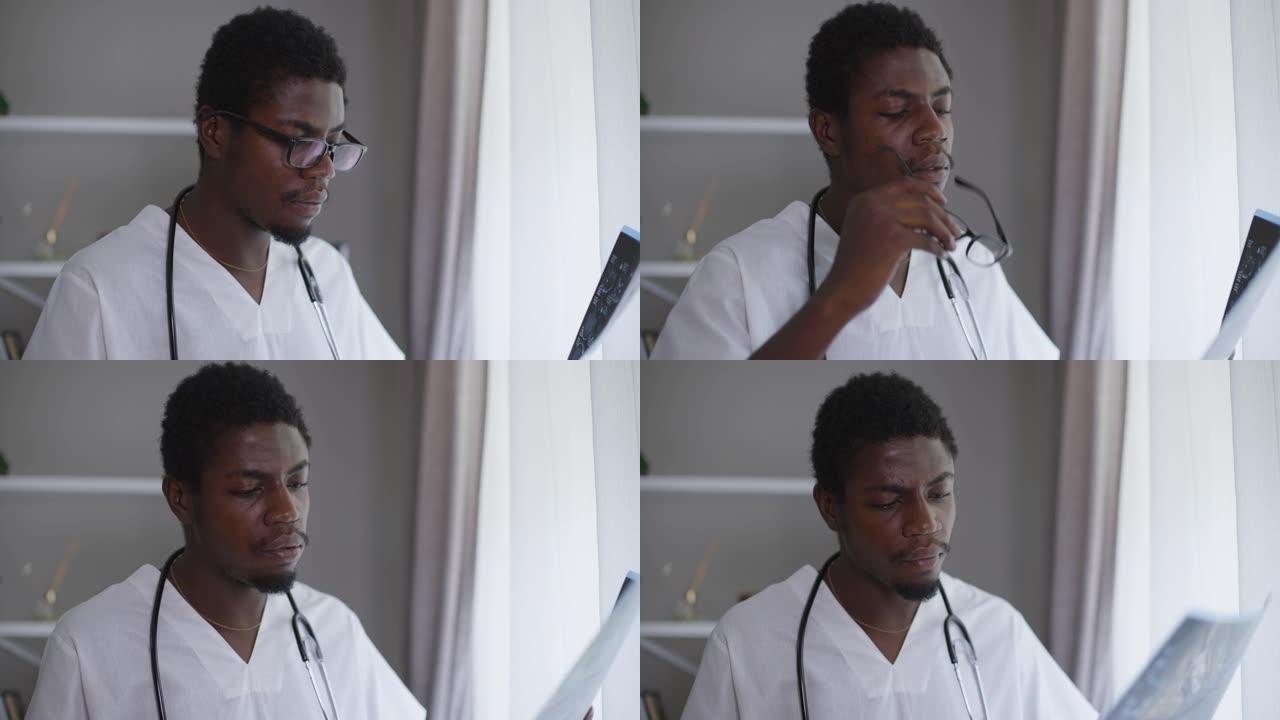 男性非裔美国神经科医生分析x光叹息脱下眼镜。不确定男医生在室内医院检查疾病。疑点和医学概念。