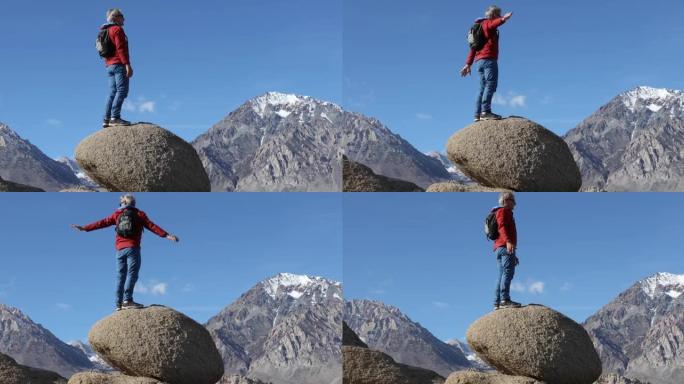 男性徒步旅行者攀登圆形巨石，远山