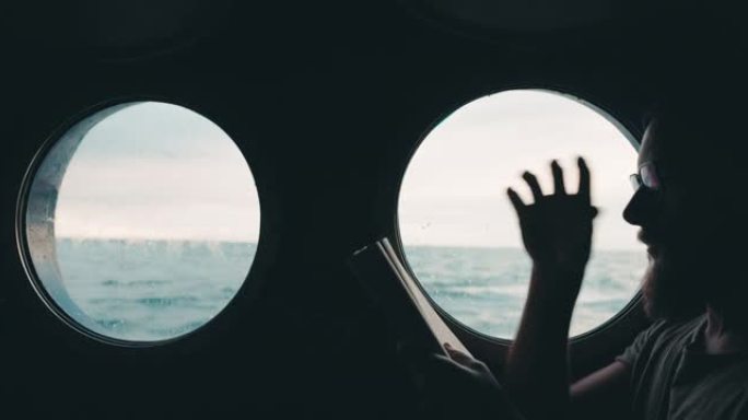 一艘航行在海上的船的舷窗上的人