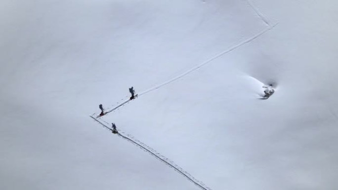 在积雪覆盖的山上的徒步旅行者的空中无人机细节拍摄