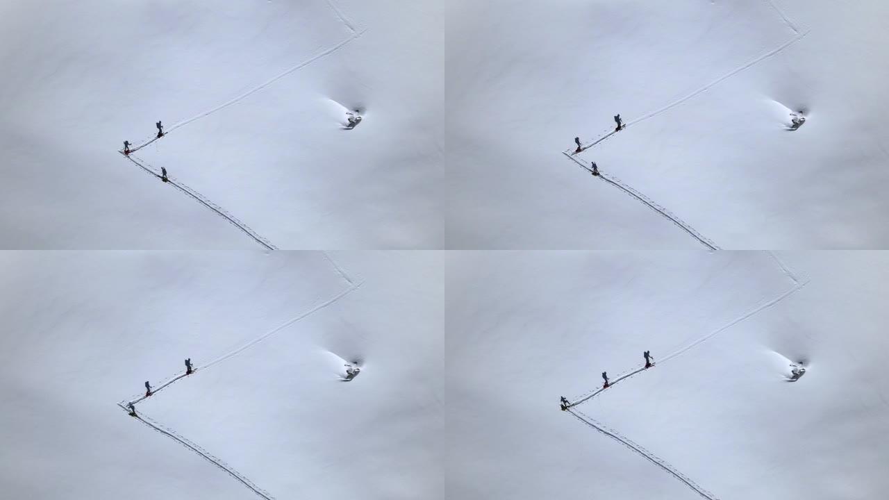 在积雪覆盖的山上的徒步旅行者的空中无人机细节拍摄