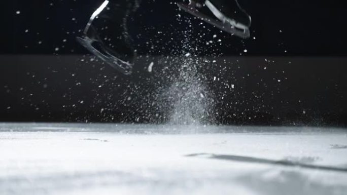 一个男人的特写镜头在溜冰鞋上向后跳。跳上溜冰鞋后，冰火花飞出。