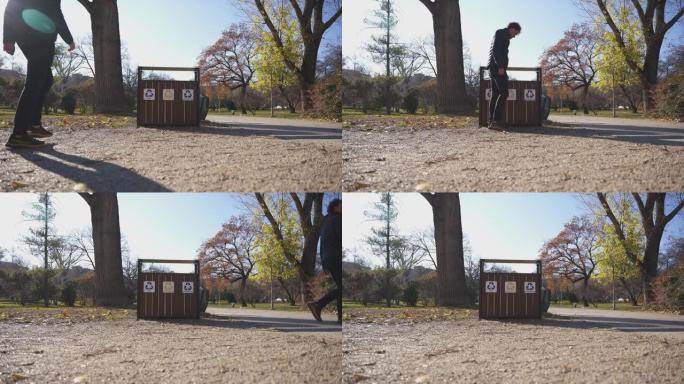 一个男人在公园的垃圾箱里扔废物的细节镜头