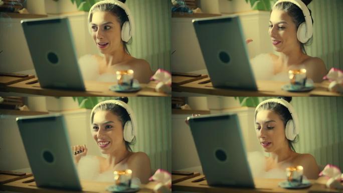 在浴室里进行视频通话。一个女人在浴缸里用笔记本电脑