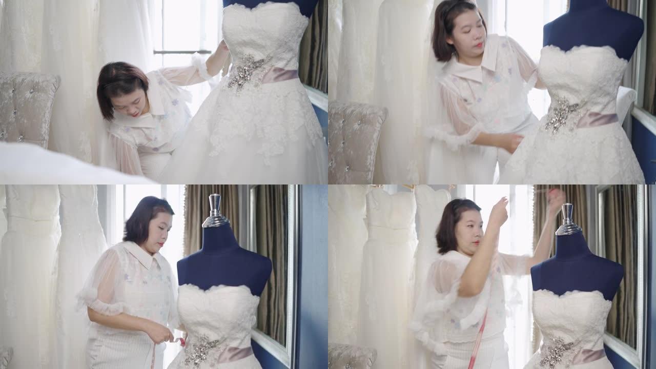 裁缝店老板婚纱室，在店里缝制一件白色婚纱。
