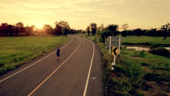 鸟瞰图，他在暮光之城的户外道路上玩直排轮滑。