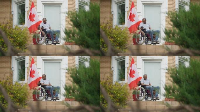坐在轮椅上的成年非裔美国人的宽幅肖像，坐在门廊上，加拿大国旗在房子上飘扬。悲伤沮丧的截瘫男子在后院思