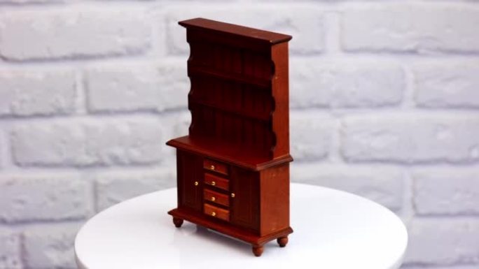 漂亮的老式棕色木头橱柜。旋转桌上可爱的玩具家具。特写。