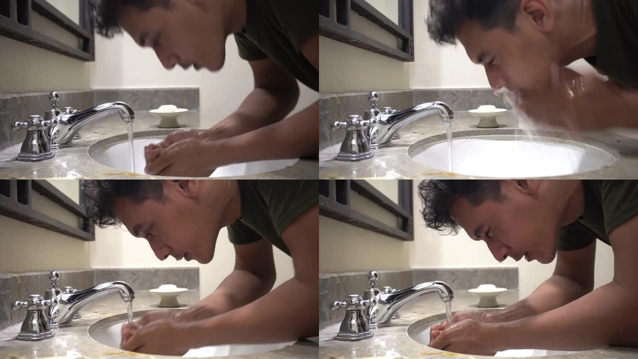 特写男人在洗手盆里洗脸和头发
