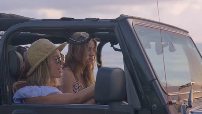 女性朋友逃到田园诗般的海滩。透过越野车窗户看。田园诗般的日落