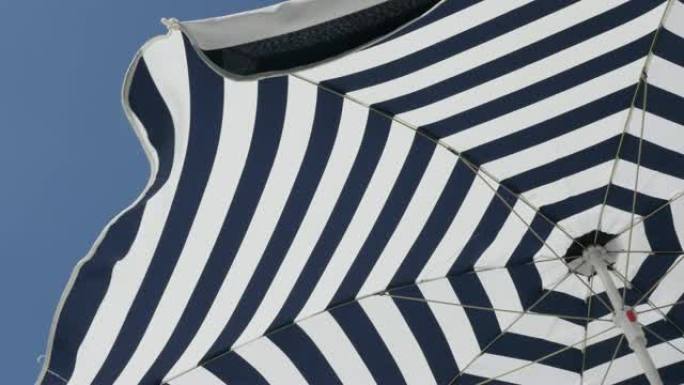 条纹雨伞防晒面料随风移动4K 2160p 30fps超高清镜头-具有催眠效果的蓝色和白色沙滩阳伞38